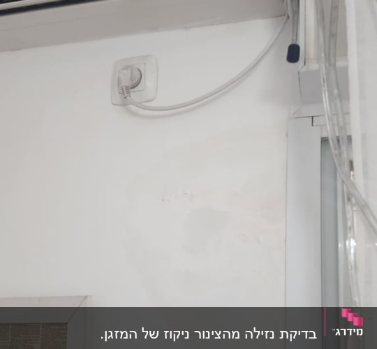 מזגן מותקן על קיר עם חוטים חשמליים
